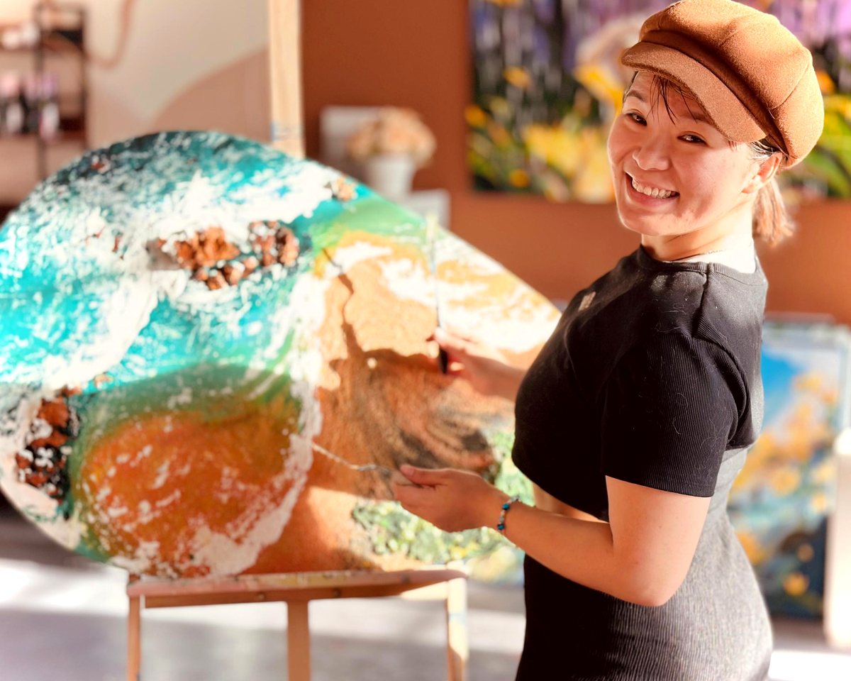 Artist working on a custom painting with mural references
