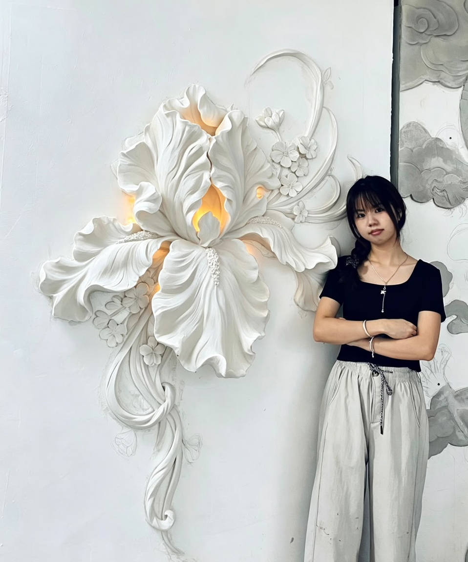 Person standing beside a large white floral relief