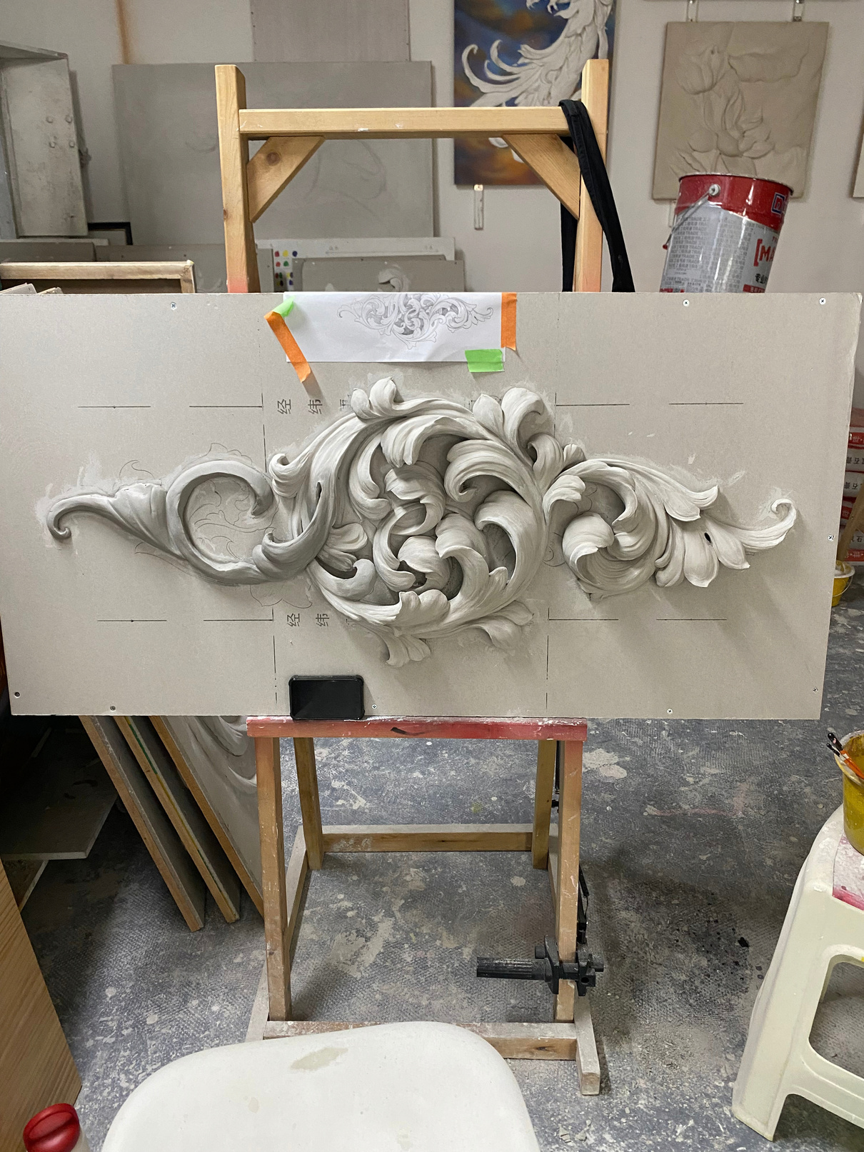 Decorative relief in progress on a workshop easel