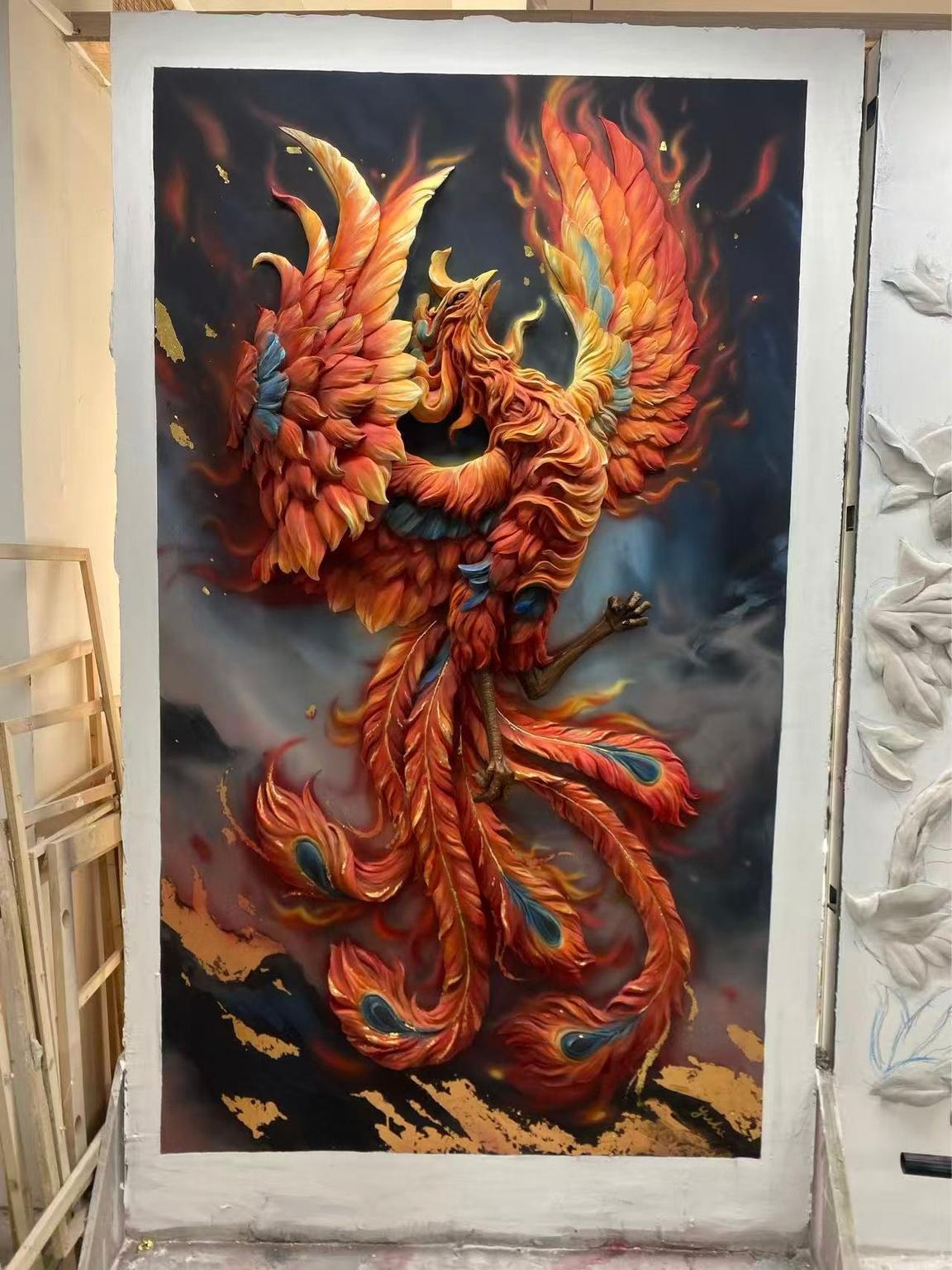 Orange and gold phoenix relief photographed on a workshop wall